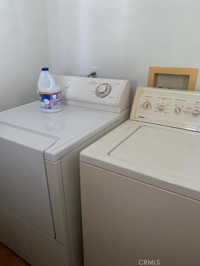 clothes washing area with washing machine and dryer