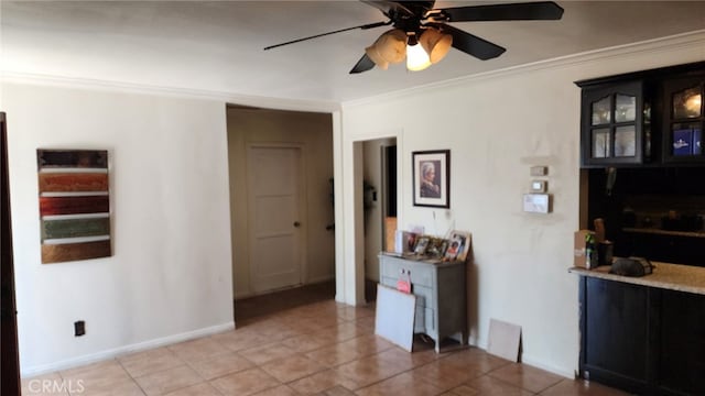 interior space with tile patterned flooring, ceiling fan, and ornamental molding