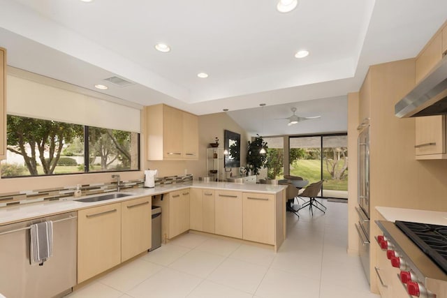 kitchen with kitchen peninsula, stainless steel appliances, ceiling fan, exhaust hood, and light brown cabinets