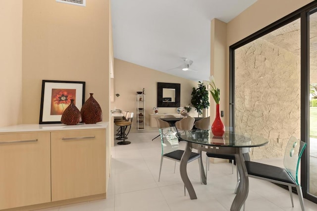 dining space featuring light tile patterned floors and vaulted ceiling