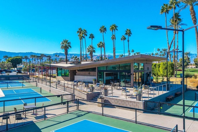 view of property's community with a mountain view and tennis court