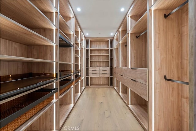 walk in closet with light hardwood / wood-style floors