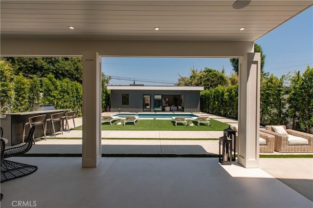 view of patio / terrace with a bar and an outbuilding