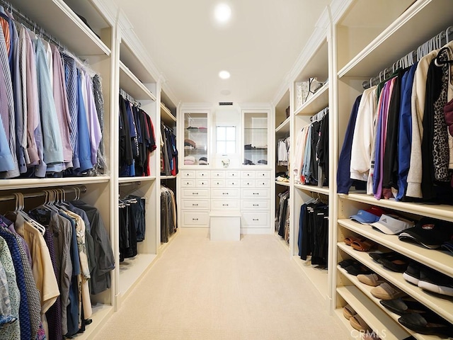 walk in closet featuring light colored carpet