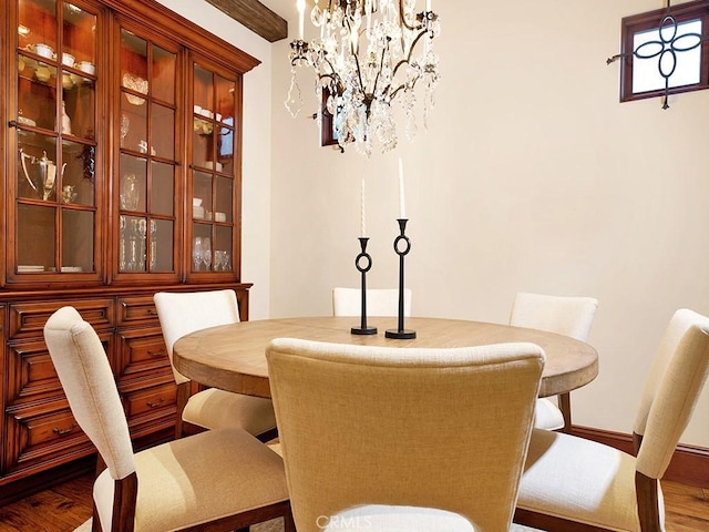 dining space with a notable chandelier and dark hardwood / wood-style flooring