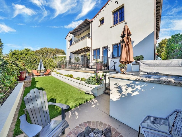 view of patio / terrace featuring a balcony and an outdoor fire pit