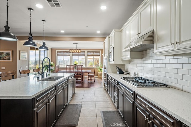 kitchen with sink, decorative light fixtures, a center island with sink, white cabinetry, and appliances with stainless steel finishes