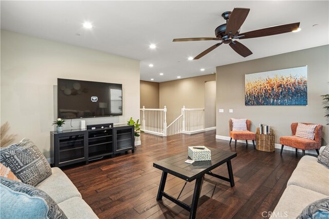 living room featuring ceiling fan and dark wood-type flooring