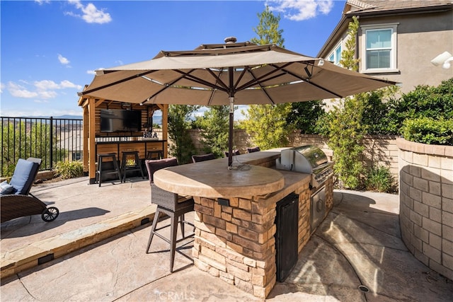 view of patio / terrace with area for grilling, exterior bar, grilling area, and a gazebo