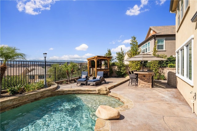 view of swimming pool featuring an outdoor bar, a gazebo, and a patio area