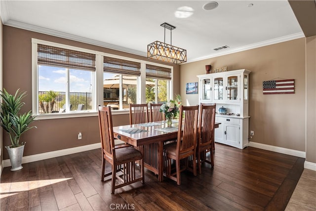 dining area featuring crown molding and dark hardwood / wood-style flooring