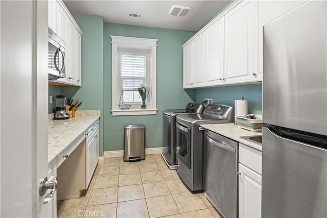 laundry room featuring light tile patterned floors and washing machine and dryer