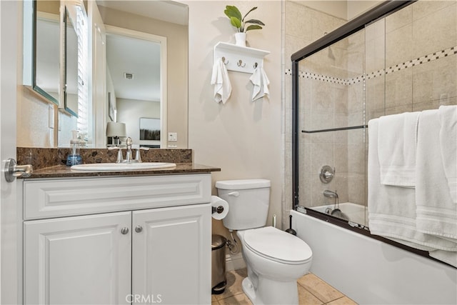 full bathroom with shower / bath combination with glass door, toilet, vanity, and tile patterned floors