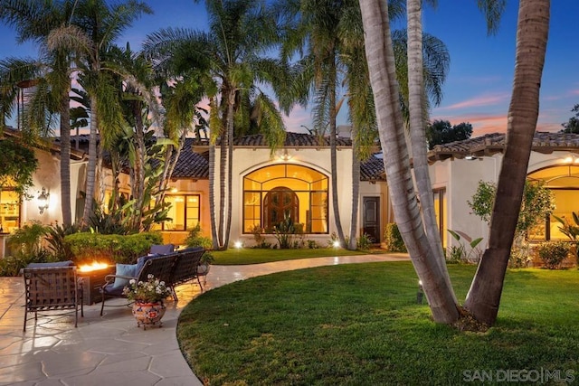 mediterranean / spanish-style house featuring a patio area and a yard