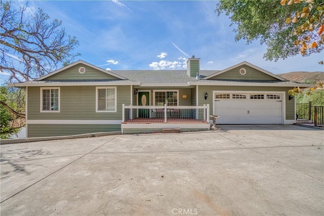 ranch-style house with driveway, a chimney, and an attached garage