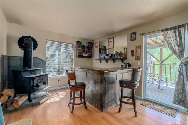 bar with hardwood / wood-style flooring and a wood stove