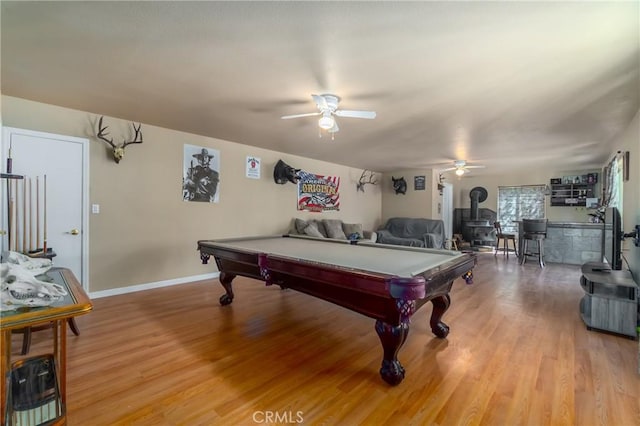 recreation room featuring ceiling fan, a wood stove, hardwood / wood-style floors, and billiards