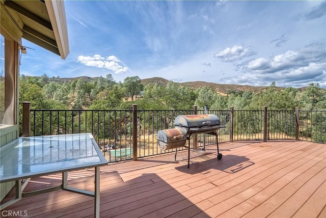 wooden deck featuring a mountain view and a grill