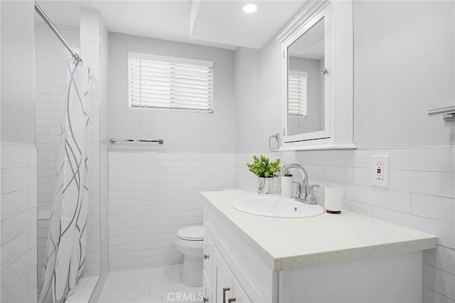 bathroom featuring a shower with shower curtain, vanity, tile walls, tile patterned flooring, and toilet