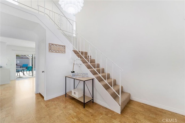 stairs with a chandelier and a high ceiling