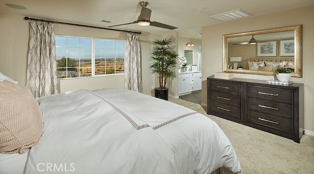 bedroom featuring connected bathroom, dark colored carpet, and ceiling fan