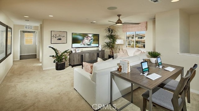 carpeted living room with ceiling fan