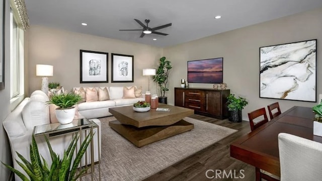 living room featuring ceiling fan and dark wood-type flooring