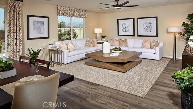 living room featuring dark hardwood / wood-style flooring and ceiling fan