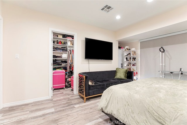 bedroom with light hardwood / wood-style floors, a spacious closet, and a closet