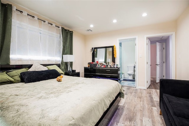 bedroom featuring light hardwood / wood-style floors and ensuite bathroom