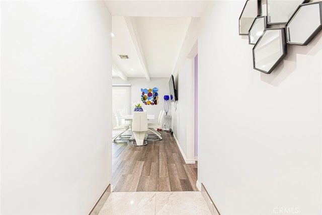 corridor with beamed ceiling and hardwood / wood-style flooring