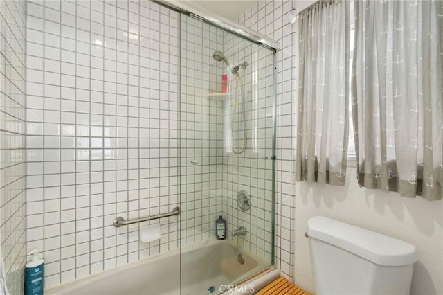 bathroom with toilet and enclosed tub / shower combo