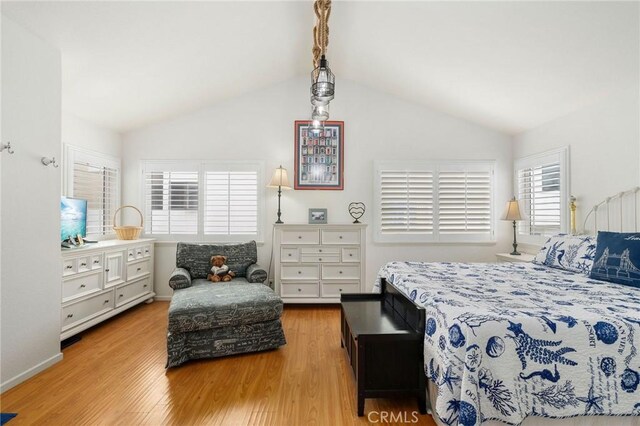 bedroom with light wood-type flooring and lofted ceiling