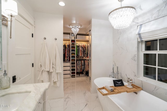 bathroom featuring vanity, a bathing tub, a notable chandelier, and tile walls