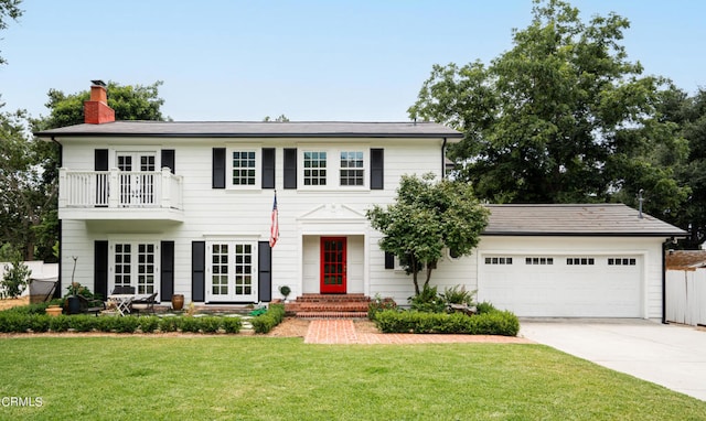 colonial home with a balcony and a front yard