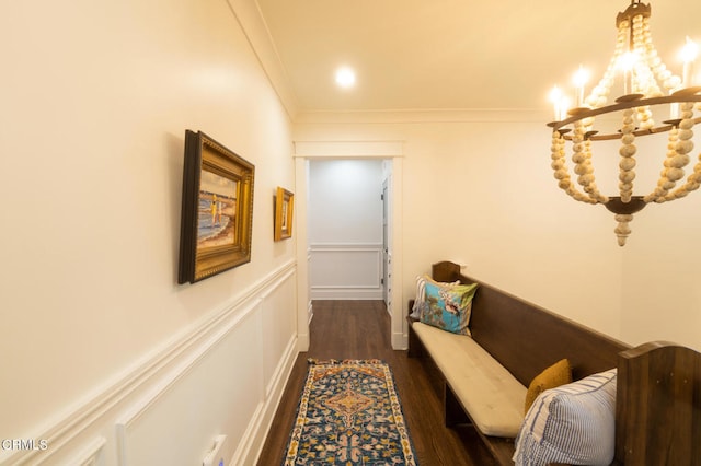 corridor with ornamental molding, a notable chandelier, and dark hardwood / wood-style flooring