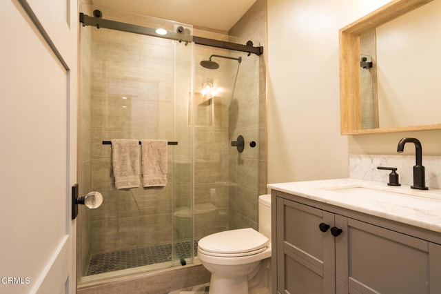 bathroom with vanity, toilet, and a shower with shower door