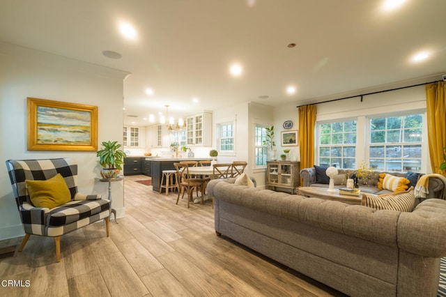 living room with light wood-type flooring and a chandelier