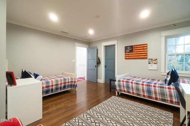 bedroom featuring ornamental molding and dark hardwood / wood-style floors