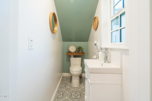 bathroom featuring lofted ceiling, vanity, and toilet