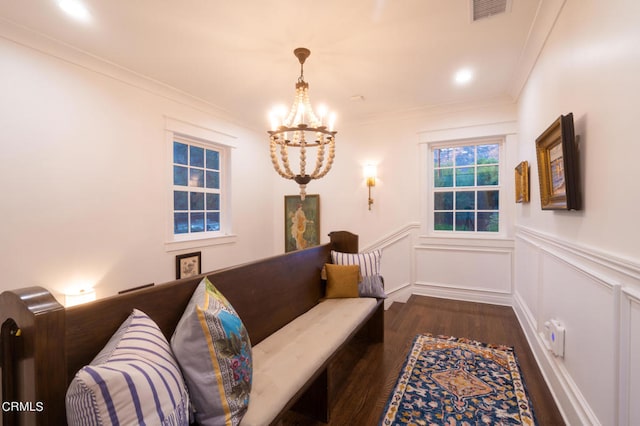 sitting room featuring an inviting chandelier, crown molding, and dark hardwood / wood-style floors