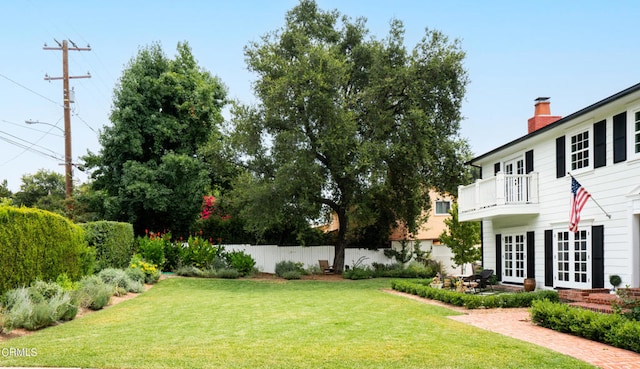 view of yard with a balcony and french doors