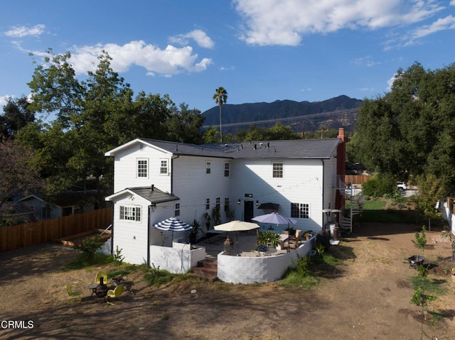 rear view of house with a mountain view and a patio area