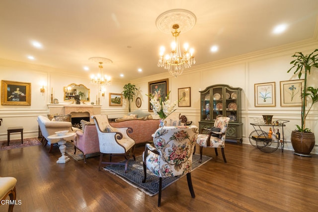 living room with ornamental molding, an inviting chandelier, dark hardwood / wood-style floors, and a premium fireplace