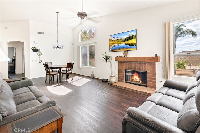 living room featuring a fireplace, vaulted ceiling, dark hardwood / wood-style floors, and ceiling fan