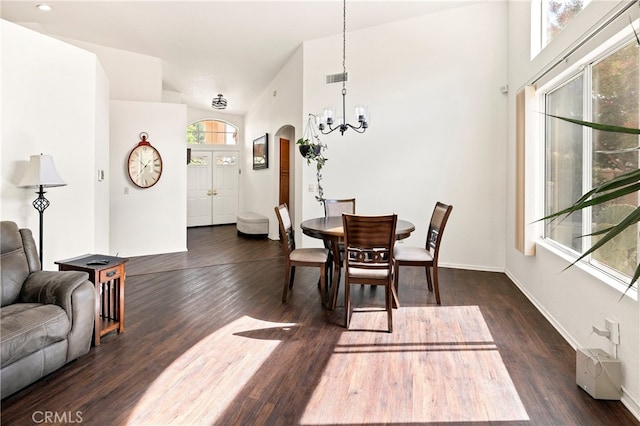 dining room featuring an inviting chandelier, lofted ceiling, and dark hardwood / wood-style floors