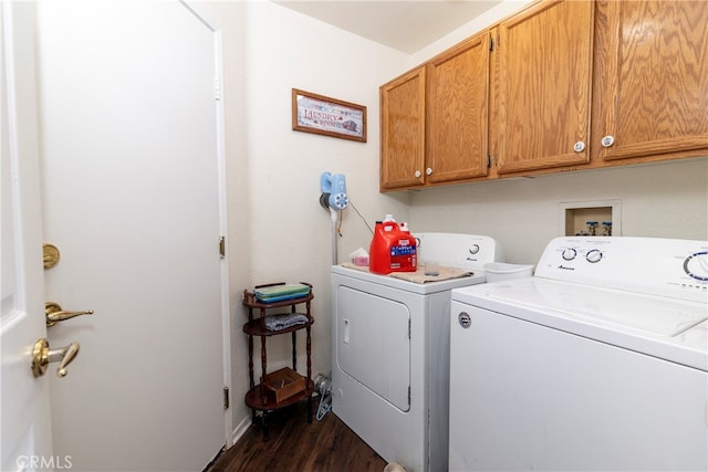 washroom with washing machine and clothes dryer, cabinets, and dark hardwood / wood-style flooring