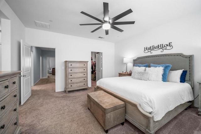 bedroom with a spacious closet, a closet, ceiling fan, and carpet floors