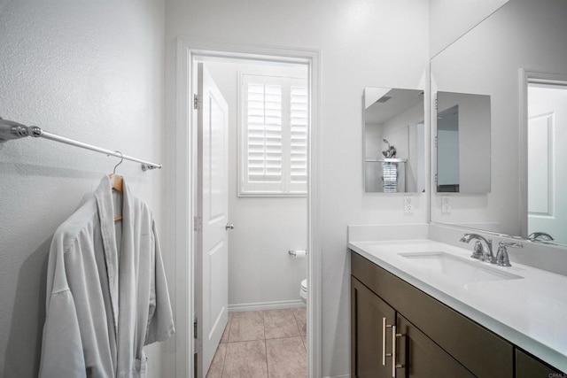 bathroom featuring vanity, tile patterned flooring, and toilet