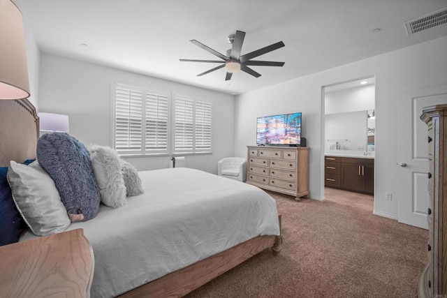 bedroom featuring light colored carpet, ceiling fan, and ensuite bathroom